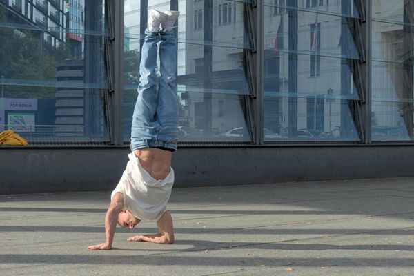 Silhouette of a man performing a fluid bodyweight exercise.